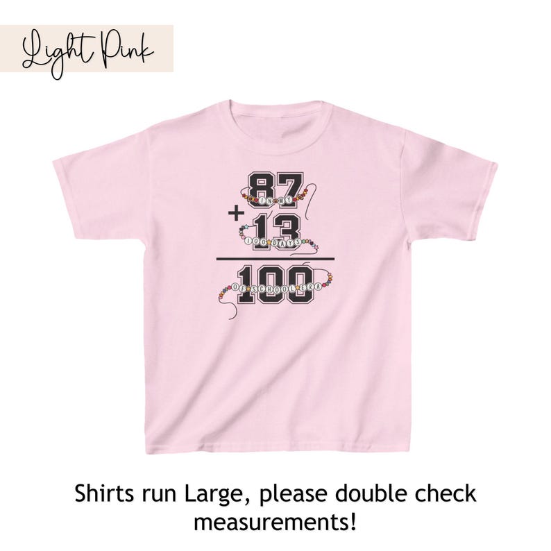May include: Light pink t-shirt with a black graphic of a math equation: 87 + 13 = 100. The numbers are made of colorful beads.