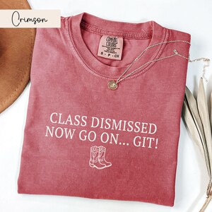 May include: Crimson red t-shirt with the text "Class Dismissed Now Go On... Git!" in white. Two white cowboy boot silhouettes are below the text.