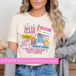 May include: A white t-shirt with a pink, blue, and yellow design featuring the words "Welcome to Math Class" and "The Only Subject That Counts!"  The design also includes a calculator, a pencil, a ruler, and a notebook. The text "Hello! My name is Mrs. Anderson" is on a pink name tag.
