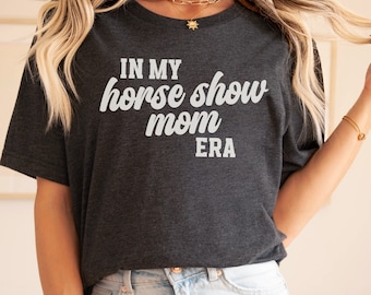 May include: A dark gray t-shirt with the text "IN MY HORSE SHOW MOM ERA" printed in white.