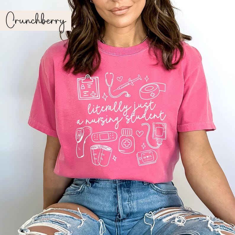 K&ouml;nnte beinhalten: Pinkes T-Shirt mit einem wei&szlig;en Grafikdesign von medizinischen Instrumenten und dem Text "im Grunde nur ein Krankenpflegesch&uuml;ler".