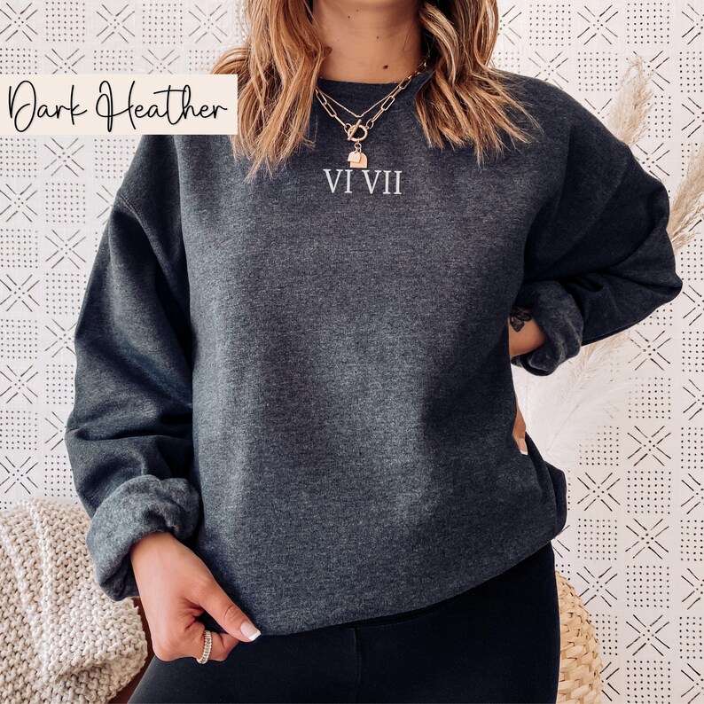 May include: Dark heather gray sweatshirt with the text "VI VII" in white. The sweatshirt has a crew neck and long sleeves. The words "Dark Heather" are written in a script font in the upper left corner.