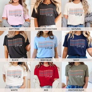 May include: A collection of t-shirts in various colors, featuring a design with the text "German Shepherd Mama" and the name "Oakley" in a smaller font. The shirts are available in soft pink, dark grey heather, natural, black, baby blue, navy, white, red, and heather olive.