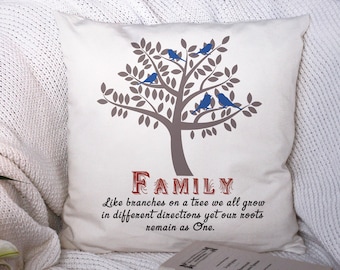 May include: A white cushion with a brown tree and blue birds printed on it. The cushion has the text "FAMILY" in red and the quote "Like branches on a tree we all grow in different directions yet our roots remain as One."