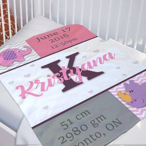 May include: A personalized baby blanket with the name "Kristyana" in pink script. The blanket features a pink and gray chevron pattern, a pink elephant, and a purple rhino. It includes the birth date, time, and measurements: 51 cm, 2980 gm.