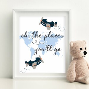 May include: A white framed print with a blue world map and two blue airplanes. The text "oh, the places you'll go" is written in black cursive font.