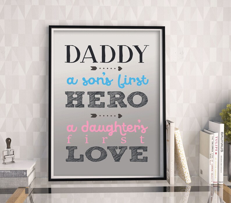 May include: A framed print with a gray background and black text that reads "Daddy... a son's first hero... a daughter's first love".