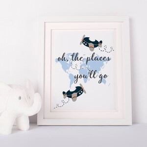 May include: A white framed print with a blue world map and two blue airplanes. The text "oh, the places you'll go" is written in black.