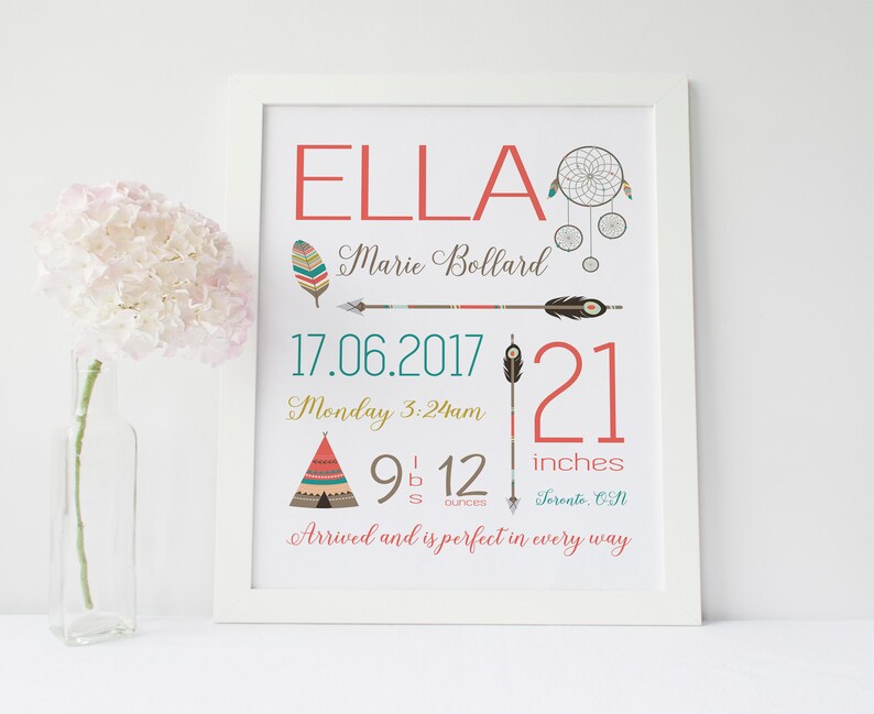 May include: A framed print with the name "ELLA" in coral letters, featuring a dreamcatcher, arrow, and teepee illustrations. The print includes the date 17.06.2017, time, weight, and height of 21 inches. A vase of pink flowers is in the foreground.