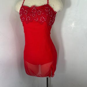 May include: A red dance costume with a sheer overlay and a lace bodice embellished with rhinestones.