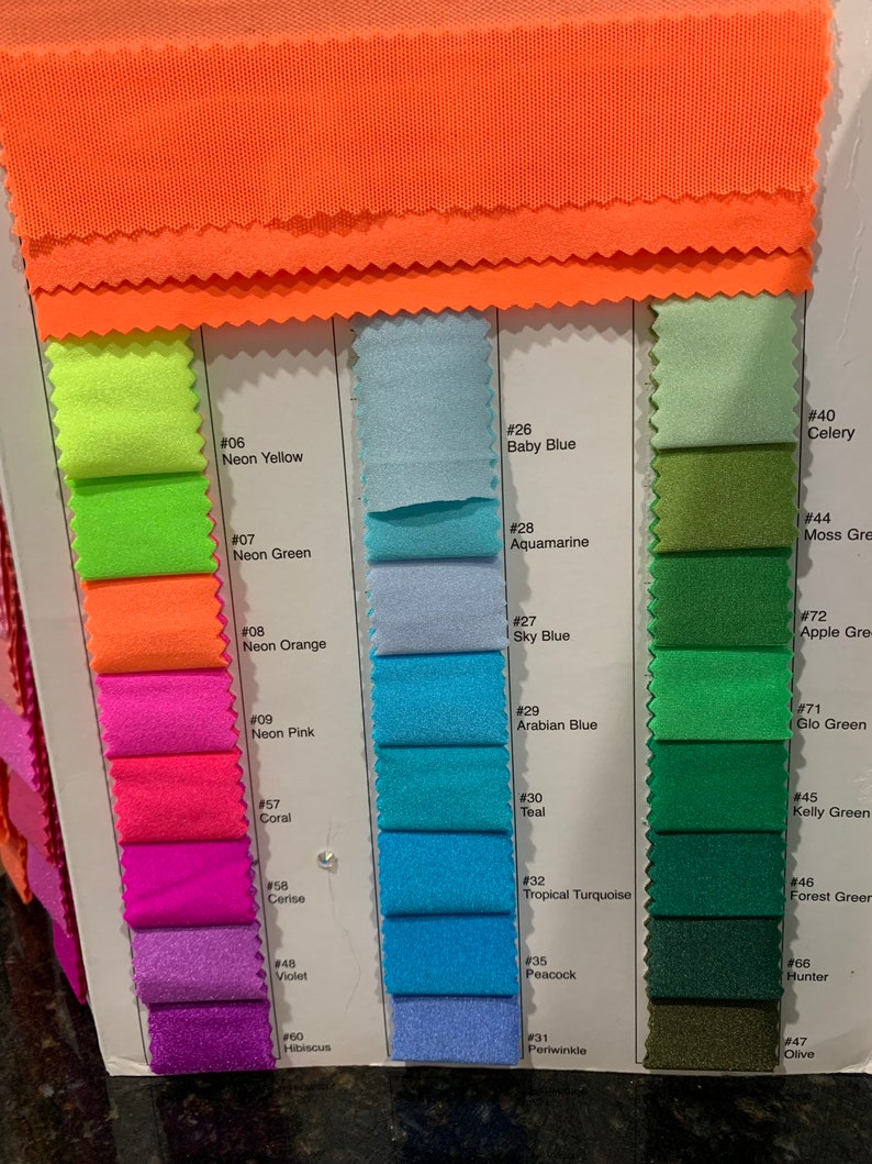 May include: A fabric colour chart displaying a range of shades. The swatches include neon yellow, neon green, neon orange, pinks, blues, greens, and purples. The card also shows the names of the colours, such as Baby Blue, Aquamarine, and Teal.