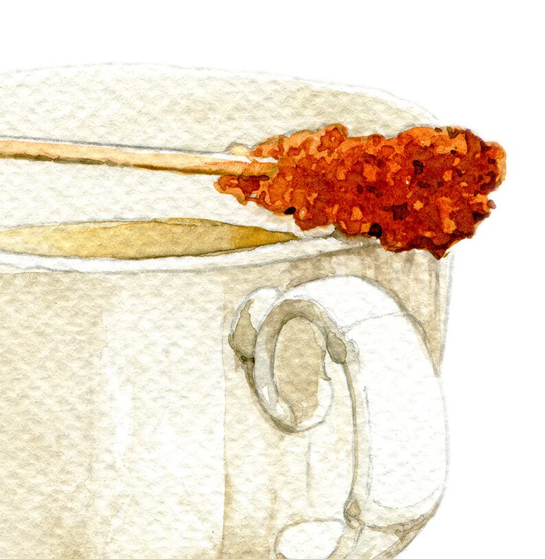 May include: A white ceramic teacup with a brown handle, filled with light brown tea. A brown sugar stick is resting on the rim of the cup.