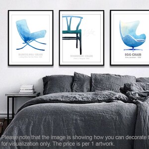 May include: Three watercolor illustrations of famous chairs: the Barcelona Chair, the Wishbone Chair, and the Egg Chair. Each illustration is framed and displayed on a white wall above a gray bed.