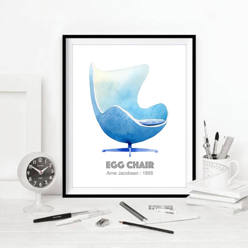 May include: A watercolor illustration of a blue Egg Chair designed by Arne Jacobsen in 1958. The chair is on a white background with the text "Egg Chair" and "Arne Jacobsen: 1958" below it.