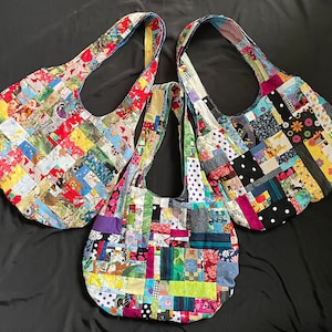 May include: Three colorful patchwork tote bags with different patterns and colors. The bags are made of fabric scraps sewn together in a patchwork style. The bags have a large, open top and a single strap.