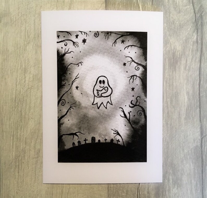 May include: A Halloween-themed greeting card featuring a watercolor illustration. The artwork depicts a friendly ghost holding a smaller ghost, surrounded by a spooky forest, stars, and a graveyard. The color palette is primarily black, white, and gray.