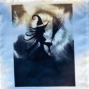 Pu&ograve; includere: Una silhouette nera di una strega che vola su una scopa su uno sfondo acquerellato blu e marrone.