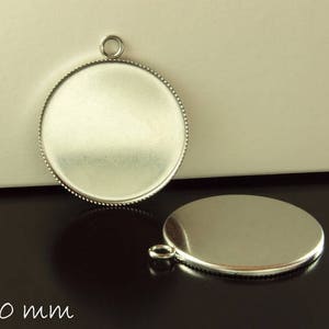 Op de afbeelding: Twee zilverkleurige ronde hangerblanks met een kralenrand en een lus om een ketting aan te bevestigen. Eén staat rechtop, de andere ligt plat. De diameter is 3 cm.