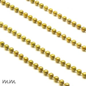 Könnte beinhalten: Nahaufnahme einer goldenen Kugelkette mit einem Durchmesser von 2 mm. Die Kette ist aus Metall und hat eine glänzende Oberfläche.