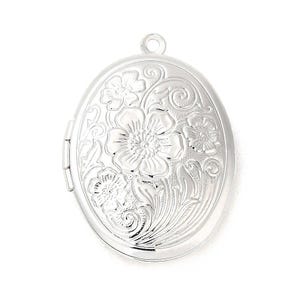 Op de afbeelding: Een zilveren ovaal medaillon met een bloemenmotief. Het medaillon heeft een scharnierende opening en een lus om een ​​ketting aan te bevestigen.
