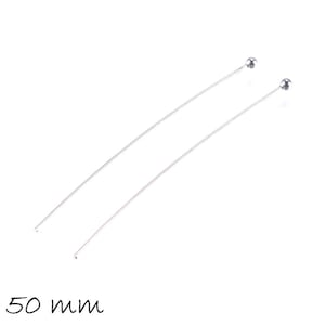 Puede incluir: Dos alfileres de cabeza plateados con cabezas redondas, cada uno mide 50 mm de largo.