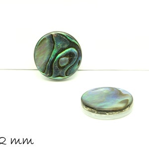 Könnte beinhalten: Zwei runde, irisierende Perlmuttknöpfe aus Abalone mit einem grün-blau-schwarzen Muster. Die Knöpfe haben einen Durchmesser von 12 mm.