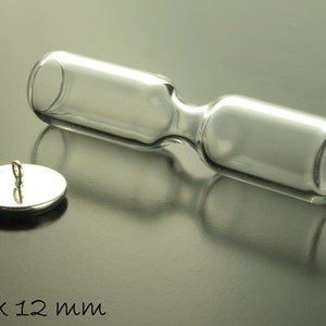 Op de afbeelding: Een glazen zandloper met een zilveren deksel en een lus om op te hangen. De zandloper is 50 x 12 mm.