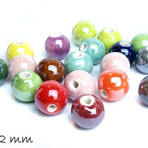 Può includere: Assortimento di perline in ceramica da 12 mm in vari colori, tra cui verde, blu, rosso, marrone, rosa e giallo. Le perline hanno una finitura liscia e lucida e un foro al centro per l'infilaggio.