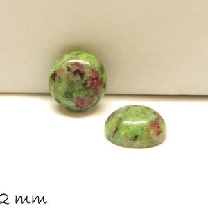 May include: Two green and pink cabochon gemstones, each measuring 12 mm in diameter.