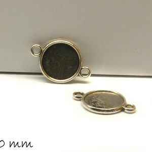 May include: Two silver-toned metal bezel settings for jewellery making. Each setting has two loops for attaching to a chain or cord. The bezels are 10 mm in diameter.