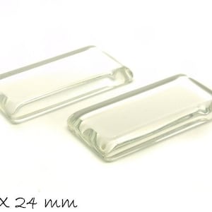 Może przedstawiać: Dwa prostokątne kształty z przezroczystego szkła, każdy o wymiarach 48 x 24 mm.