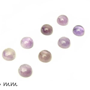 Könnte beinhalten: Acht runde, violette Amethyst-Cabochons, jeder mit einem Durchmesser von 6 mm, in einer Reihe auf weißem Hintergrund angeordnet.