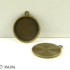 Könnte beinhalten: Zwei bronzene Metall-Anhänger-Tabletts, eines mit glatter Oberfläche und das andere mit strukturierter Oberfläche. Beide Tabletts haben einen Durchmesser von 20 mm.