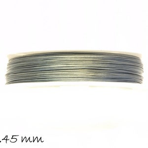 Può includere: Un rotolo di filo grigio scuro con un diametro di 0,45 mm. Il filo è avvolto strettamente sul rotolo ed è pronto per essere utilizzato per l'artigianato o altri progetti.