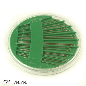 Könnte beinhalten: Ein runder, transparenter Plastikbehälter mit grünem Deckel enthält eine Sammlung von Nähnadeln. Die Nadeln sind fächerförmig angeordnet und etwa 38 bis 51 mm lang.