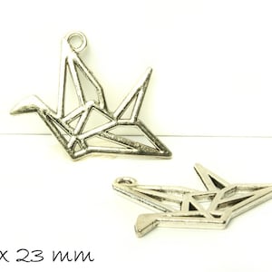 Può includere: Due ciondoli a forma di gru origami argentati, ciascuno misura 26 x 23 mm. I ciondoli sono in metallo e hanno un design delicato e intricato.