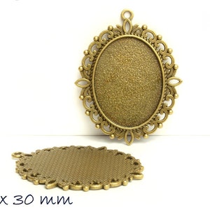 Op de afbeelding: Een ovale hanger van goudkleurig metaal met een decoratief filigraanontwerp. De hanger meet 40 x 30 mm.