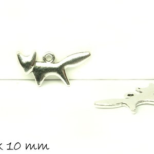 Könnte beinhalten: Zwei silberfarbene Fuchs-Anhänger. Jeder Anhänger hat die Form eines stilisierten Fuchses mit einer Schlaufe zum Aufhängen. Die Anhänger messen 20 x 10 mm. Die Fuchs-Anhänger befinden sich auf weißem Hintergrund.