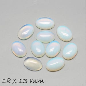 Könnte beinhalten: Zehn ovale, irisierende weiße Opal-Cabochons, jeweils 18 x 13 mm groß. Die Cabochons sind glatt und poliert, mit einer milchig weißen Farbe und einem dezenten Regenbogen-Schimmer.