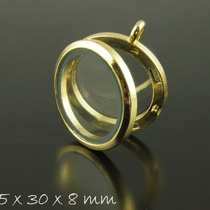 Könnte beinhalten: Goldfarbener Anhänger mit einem klaren Glaseinsatz. Der Anhänger ist 35,5 mm x 30 mm x 8 mm groß.
