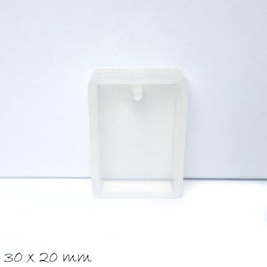 Op de afbeelding: Een transparante rechthoekige siliconen mal met een gat aan de bovenkant om op te hangen. De mal is 30 x 20 mm.