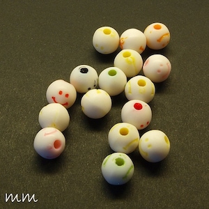 Könnte beinhalten: Eine Sammlung von 14 weißen runden Perlen mit verschiedenen bunten Designs. Die Perlen haben einen Durchmesser von etwa 7 mm.