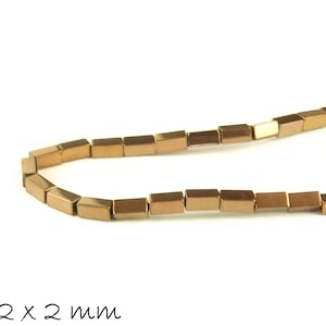 Peut inclure: Un brin de perles en métal doré, chaque perle est un prisme rectangulaire aux bords arrondis. Les perles mesurent 4 mm x 2 mm x 2 mm.