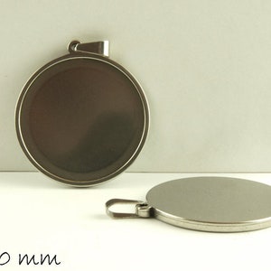 May include: Two silver round metal pendants with a diameter of 30 mm. The pendants have a smooth, shiny surface and a loop at the top for attaching to a chain or cord.