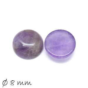 Könnte beinhalten: Zwei runde, flache Amethyststeine, jeder mit einem Durchmesser von 8 mm. Die Steine sind hellviolett und haben eine glatte, polierte Oberfläche.