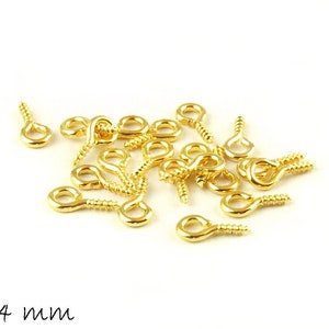 Peut inclure: Gros plan sur un tas de crochets à œillets dorés à visser, mesurant chacun 8 mm sur 4 mm.