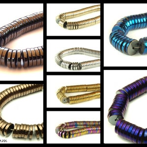 Può includere: Una selezione di perline rotonde in ematite da 10 mm per 2 mm in vari colori, tra cui marrone, argento, blu, viola e oro. Le perline sono impilate in un motivo circolare, creando un aspetto decorativo ed elegante.