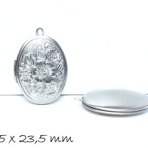 Könnte beinhalten: Silbernes ovales Medaillon mit Blumenmuster. Das Medaillon misst 33,5 mm x 23,5 mm.