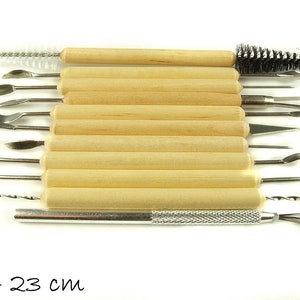Può includere: Un set di 13 strumenti da scultura con manico in legno e punte in metallo, tra cui un pennello, un trapano e vari strumenti da scultura. Gli strumenti variano in dimensioni da 13 a 23 cm.