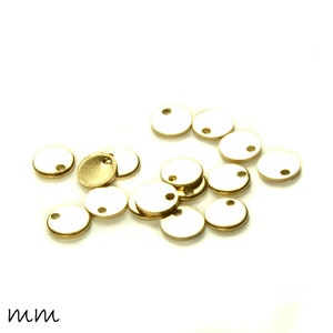 May include: A group of 12 gold-colored metal discs with a hole in the center. The discs are 6 mm in diameter and are scattered on a white surface.